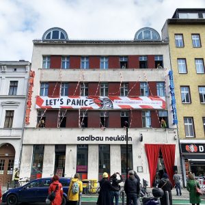 Fassade Saalbau Neukölln mit Banner "Lets Panic"